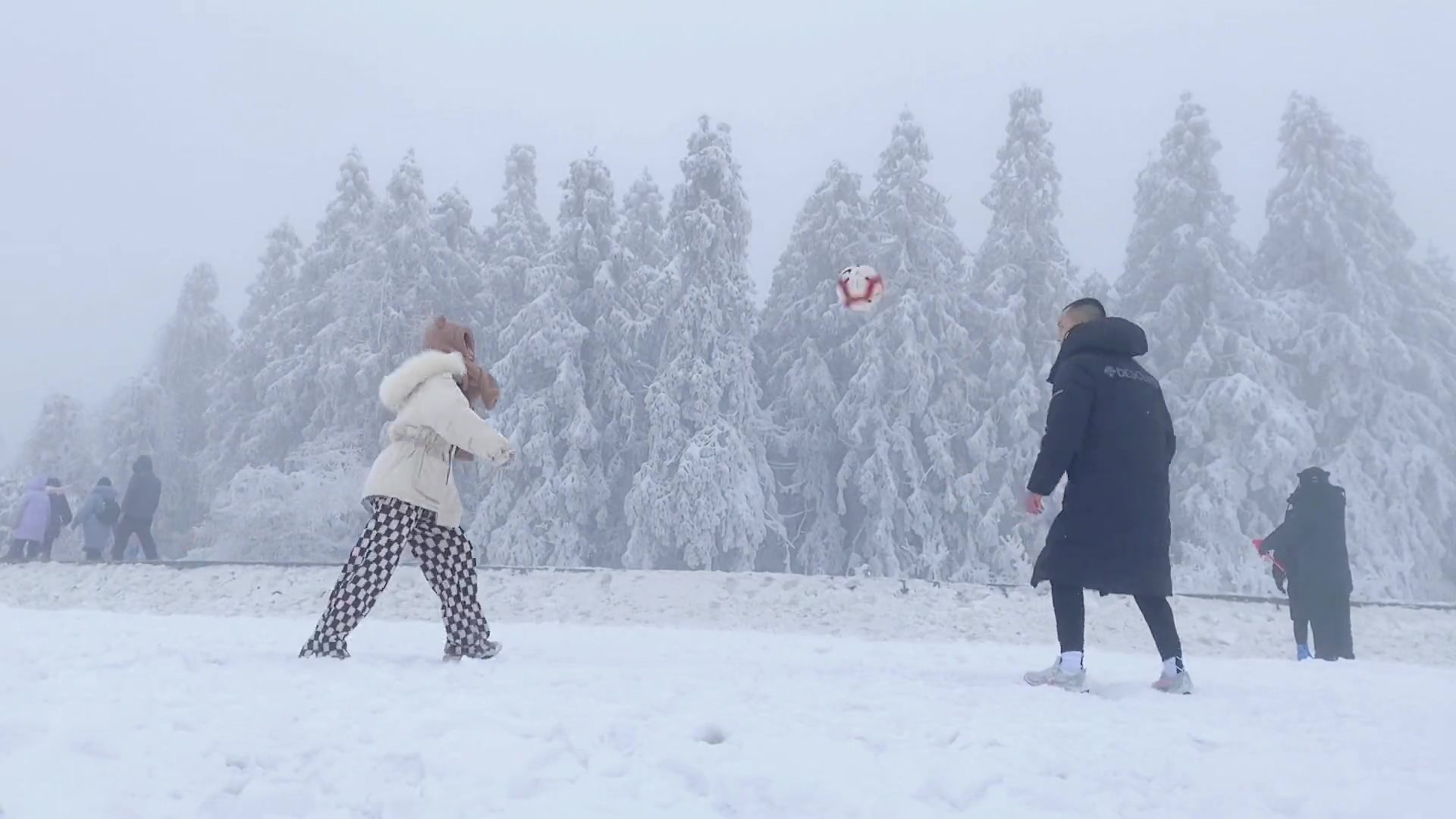 太羡慕了！热爱足球的小两口在雪地里玩颠球