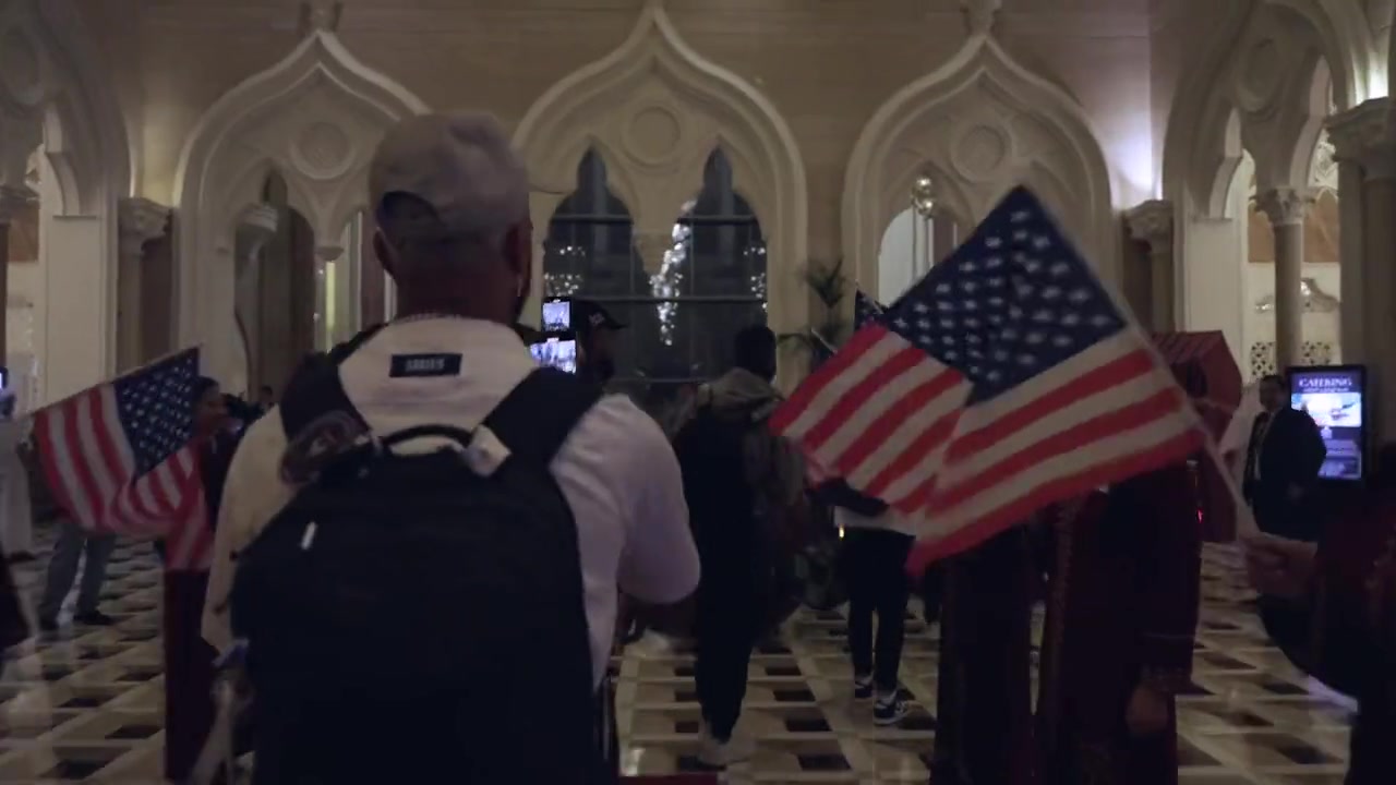 美国队抵达多哈酒店，工作人员挥舞美国国旗欢迎
